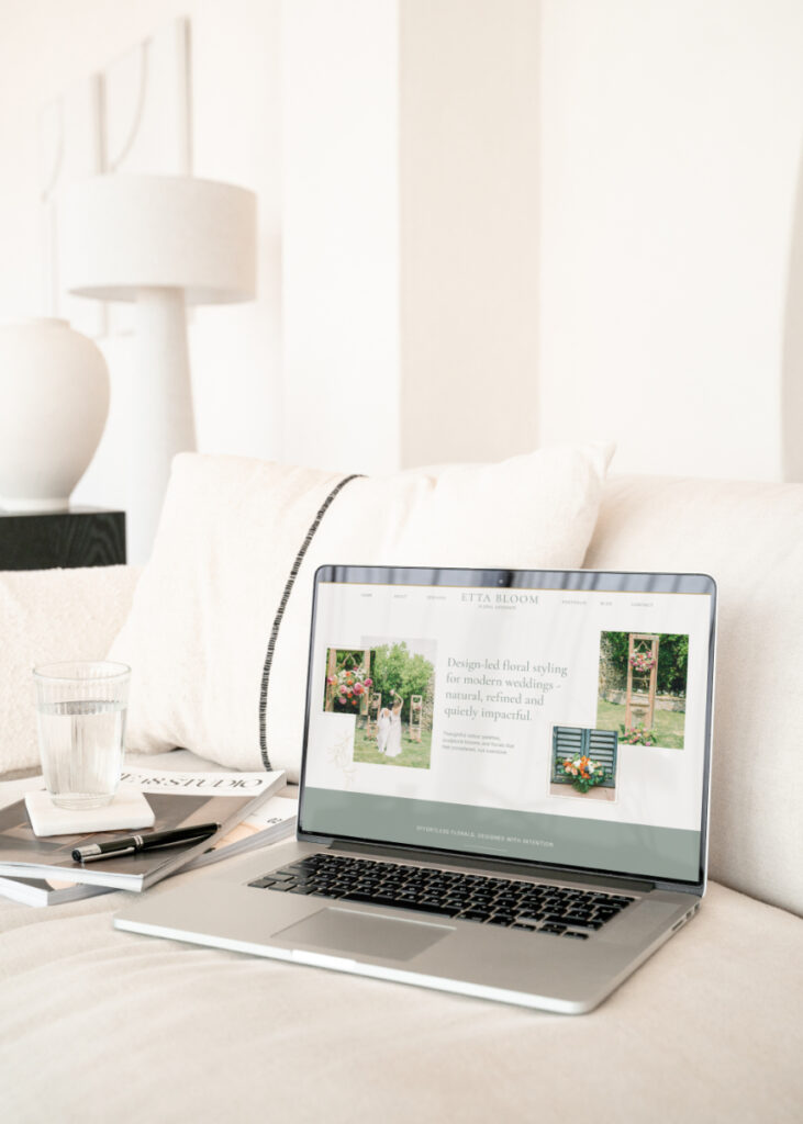 Image of a laptop on a light sofa, with a website template for wedding florists on the screen.